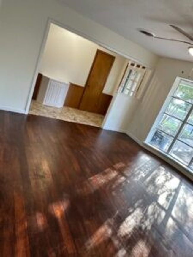 Empty room with wood finished floors and a ceiling fan | Image 10