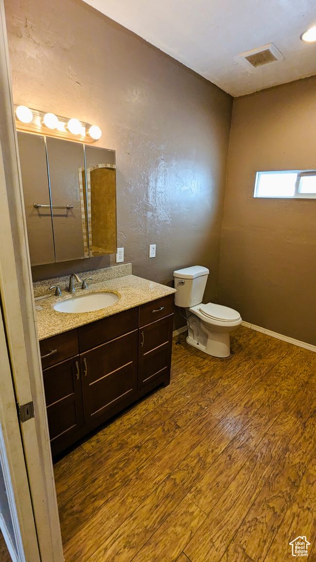 Bathroom featuring hardwood / wood-style flooring, vanity, and toilet | Image 37