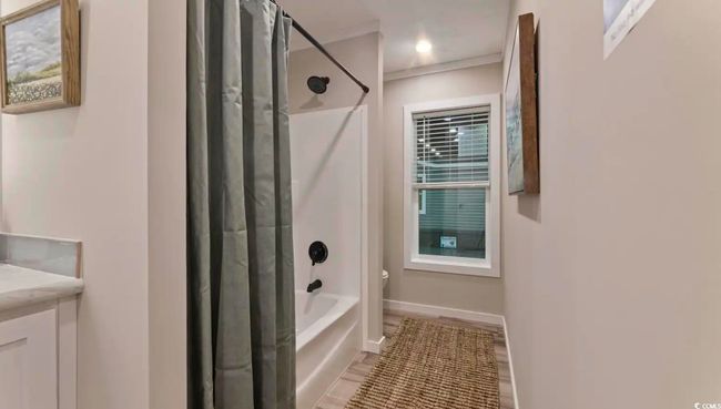 Full bathroom with shower / tub combo with curtain, toilet, vanity, and baseboards | Image 33
