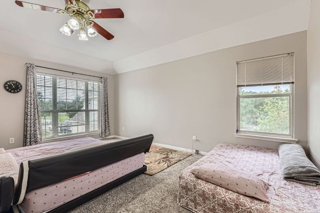 Bedroom with multiple windows, carpet, and ceiling fan | Image 20
