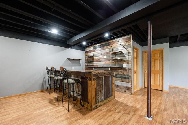 Indoor dry bar with wood finished floors and baseboards | Image 33