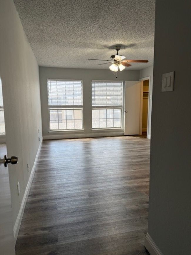 Spare room featuring a textured ceiling, a ceiling fan, and wood finished floors | Image 4