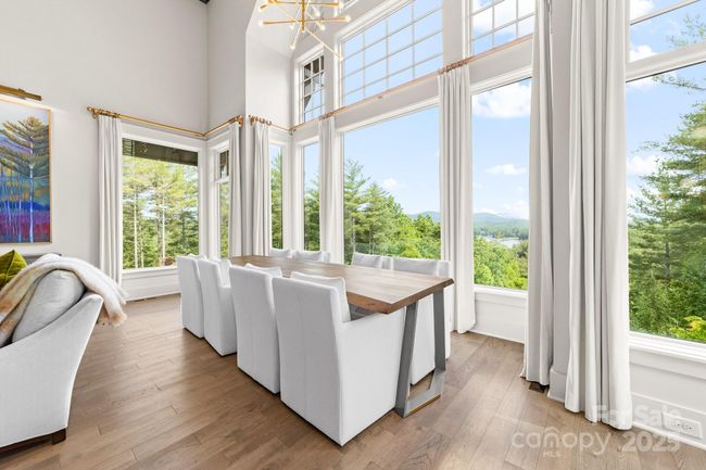 Abundant light fills the dining and living area while the expansive windows provide a full view of nature. | Image 5
