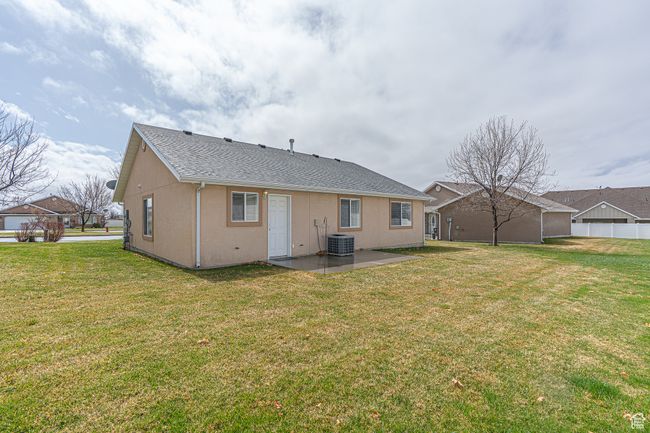 Rear view of house with a lawn, cooling unit, stucco siding, and a patio area | Image 28