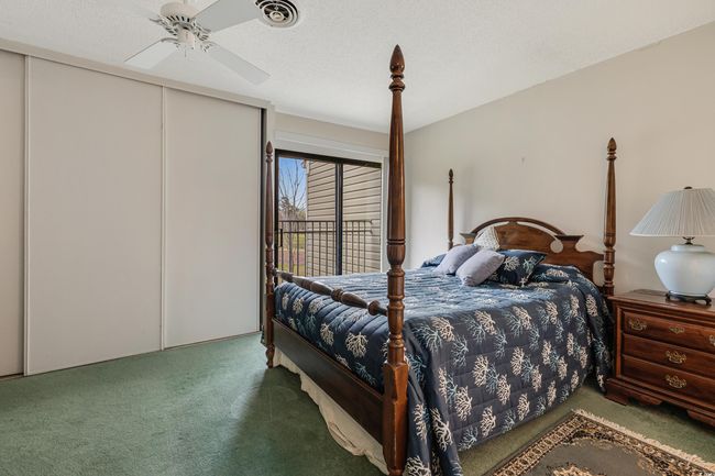 Carpeted bedroom featuring access to exterior, a textured ceiling, visible vents, and a ceiling fan | Image 23