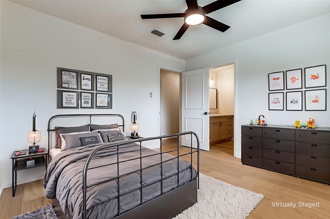 Bedroom featuring light wood-style flooring, connected bathroom, and a ceiling fan | Image 15