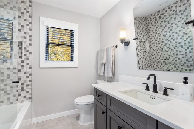 Full bathroom with toilet, shower combination, vanity, and baseboards | Image 17