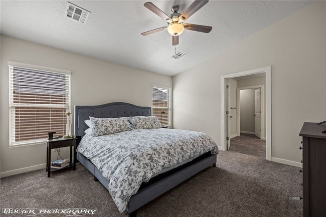 Carpeted bedroom featuring baseboards, lofted ceiling, a ceiling fan, and a textured ceiling | Image 37