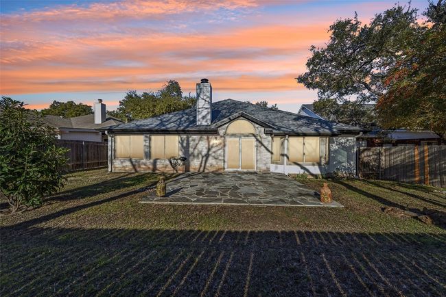 Back of property at dusk with a patio area, a fenced backyard, a lawn, and a chimney | Image 37