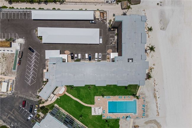 From above, the rooftop reveals the full property—lush grounds, the sparkling community pool, and pathways all leading toward the beach beyond. | Image 29