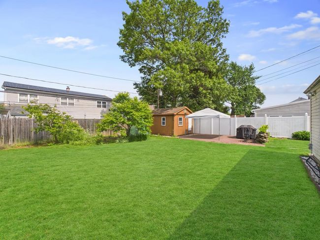 Fenced backyard featuring a patio area and a storage shed | Image 28