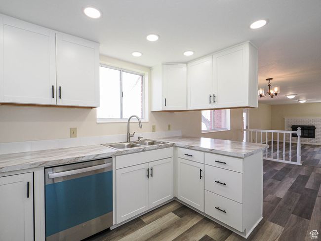 Kitchen with dishwasher, light countertops, white cabinetry, dark wood finished floors, and a peninsula | Image 31