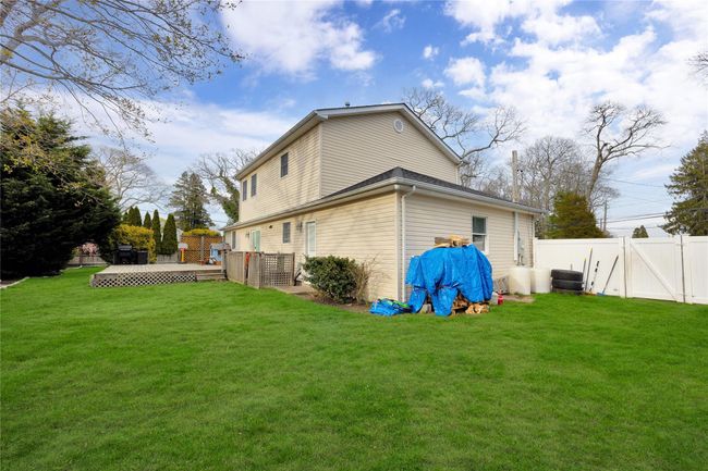 Back of house with a fenced backyard, a yard, and a deck | Image 21