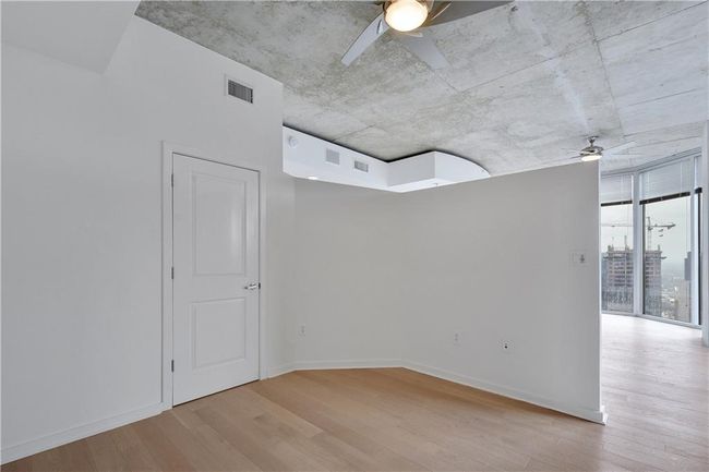 Spare room featuring baseboards, visible vents, wood finished floors, and a ceiling fan | Image 14
