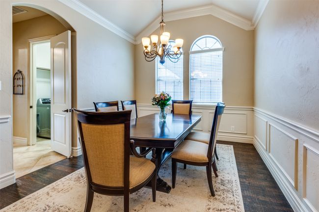 Dining area with arched walkways, lofted ceiling, crown molding, and an inviting chandelier | Image 7