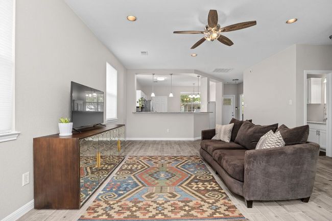 Living area featuring recessed lighting, ceiling fan, wood finished floors, and a healthy amount of sunlight | Image 7