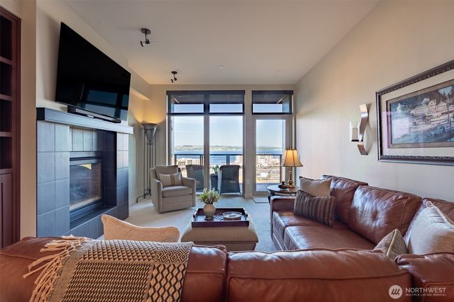 The living room has a dual sided fireplace for warmth and ambiance. Spectacular views off the balcony are just one of the many amenities. | Image 9