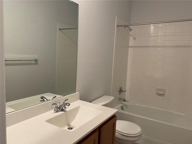 Full bath with toilet, vanity, shower combination, and a textured wall | Image 8