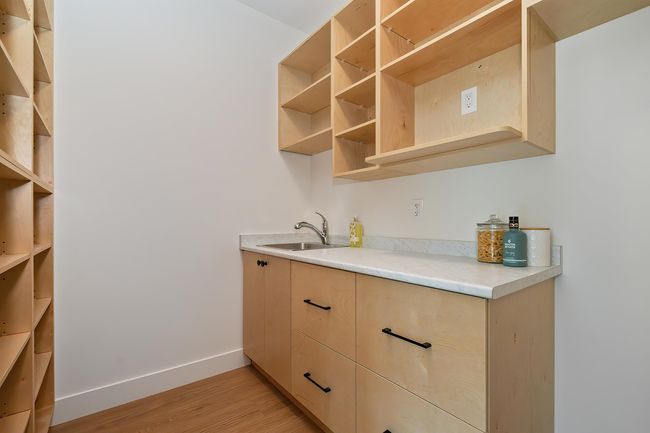 Kitchen featuring light brown cabinetry, open shelves, light wood finished floors, and light countertops | Image 8