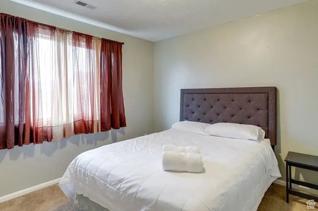 Carpeted bedroom featuring baseboards and visible vents | Image 12