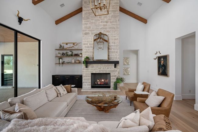 Living area with visible vents, a stone fireplace, wood finished floors, high vaulted ceiling, and beamed ceiling | Image 6