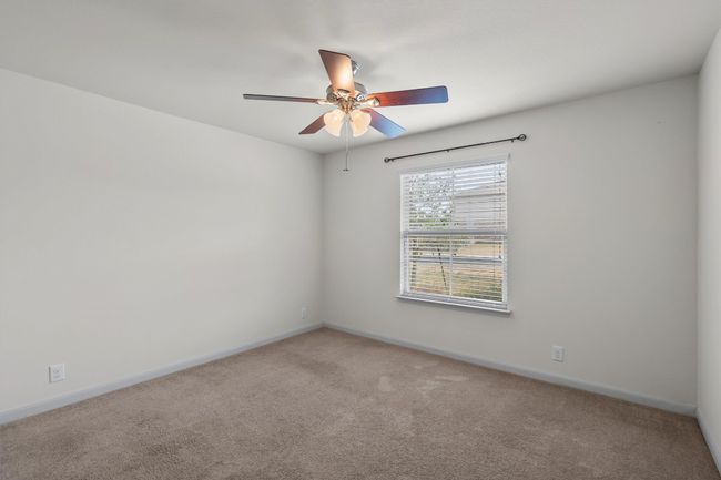 Bedroom 1 with a ceiling fan and carpet flooring. | Image 15