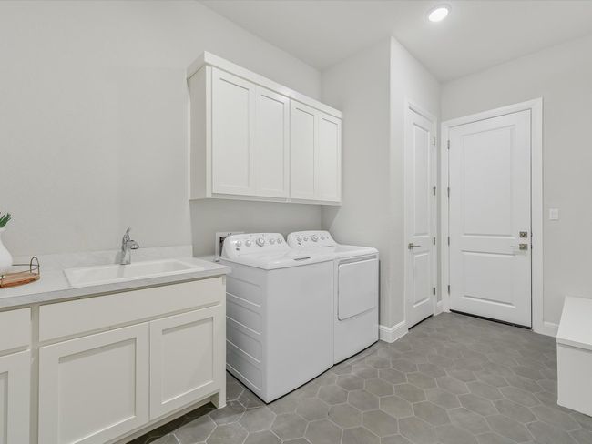Laundry room featuring cabinet space, independent washer and dryer, recessed lighting, and light tile patterned flooring | Image 32