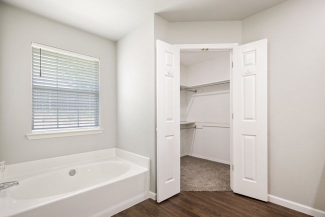 Bathroom with wood finished floors, a bath, and a walk in closet | Image 17