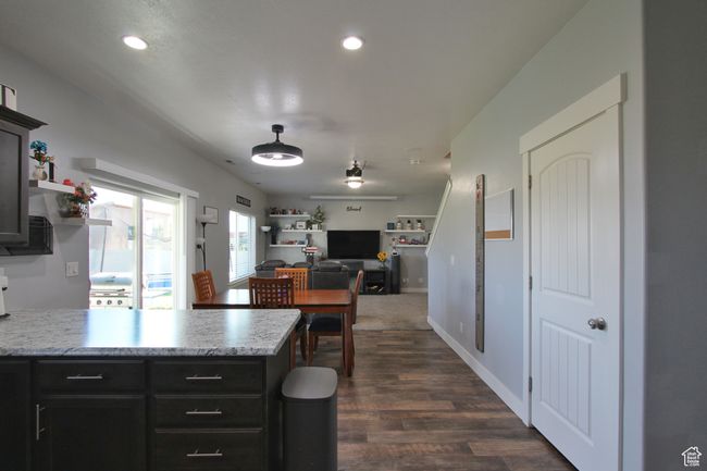 Kitchen with light countertops, a peninsula, dark wood-style floors, recessed lighting, and open floor plan | Image 8