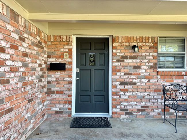 View of exterior entry featuring a porch and brick siding | Image 4