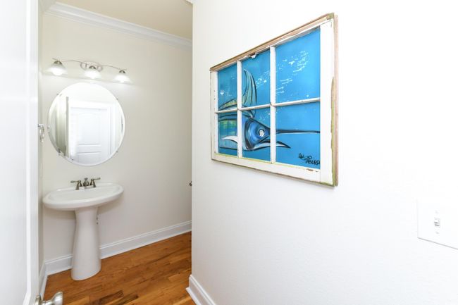 Bathroom featuring a sink, baseboards, ornamental molding, and wood finished floors | Image 20