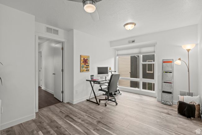 Home office featuring wood finished floors, a ceiling fan, and a textured ceiling | Image 30