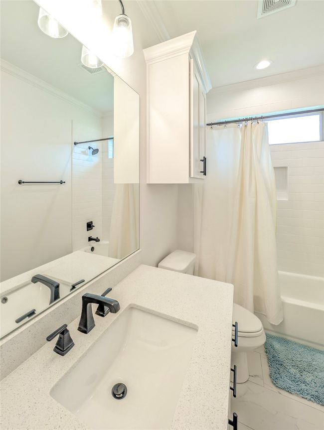 Bathroom featuring ornamental molding, shower / tub combo, vanity, recessed lighting, and marble look tile flooring | Image 32