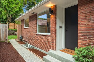 The formal entry is covered and the sidewalk wraps around to the back door and fenced backyard. | Image 3