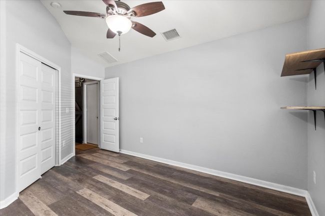 Unfurnished bedroom featuring lofted ceiling, dark wood-style flooring, baseboards, and a closet | Image 26