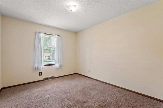 Carpeted empty room with a textured ceiling and baseboards | Image 17