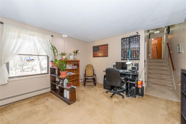 Office with a baseboard radiator, carpet flooring, and a textured ceiling | Image 16