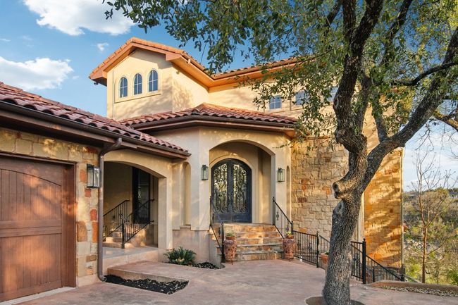 View of exterior entry with a tiled roof, french doors, stone siding, and stucco siding | Image 5