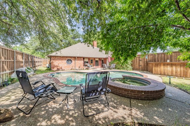 View of swimming pool featuring a patio, a fenced backyard, and a pool with connected hot tub | Image 23