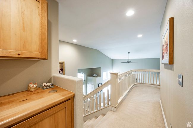 Bedroom with arched walkways, light colored carpet, and ceiling fan | Image 19