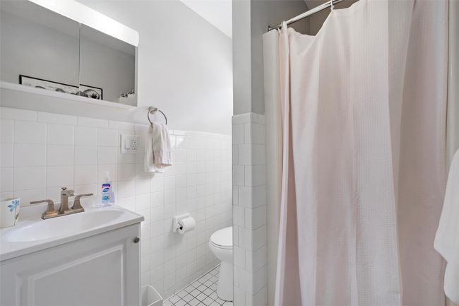 Bathroom featuring tile walls, a shower with shower curtain, toilet, vanity, and tile patterned floors | Image 24