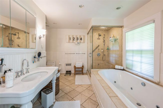 Primary spa-like bathroom features a steam shower and jacuzzi tub. | Image 22