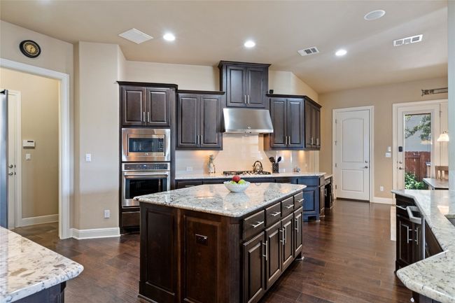 Kitchen Features Granite Countertops, Gas Cooking and Center Island | Image 9