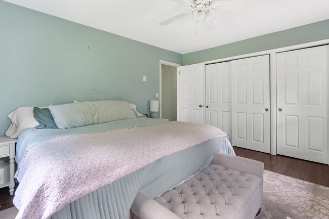 Bedroom with dark wood finished floors and a ceiling fan | Image 26