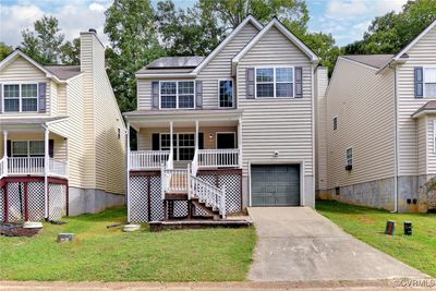 View of front of property with a front yard, covered porch, and a garage | Image 2