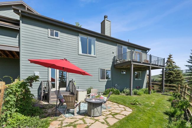 Back of property featuring a balcony, an outdoor fire pit, a chimney, and a patio area | Image 43