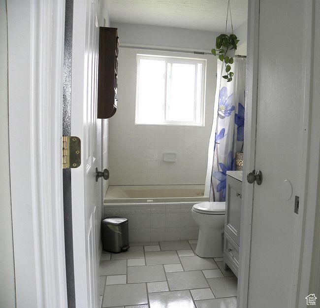 Full bath with toilet, tile patterned flooring, and tiled shower / bath | Image 21