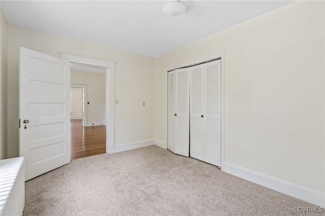Bedroom with carpet flooring, a closet, and baseboards | Image 12