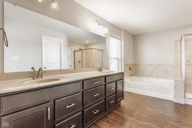 full bathroom featuring a garden tub, a sink, double vanity, and a stall shower | Image 28