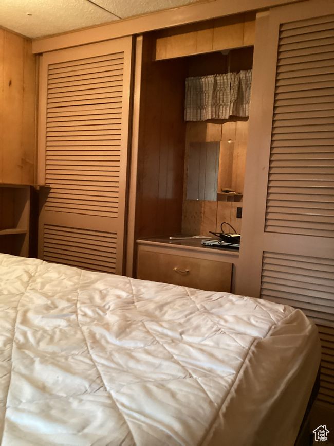 Bedroom with a closet and wooden walls | Image 22